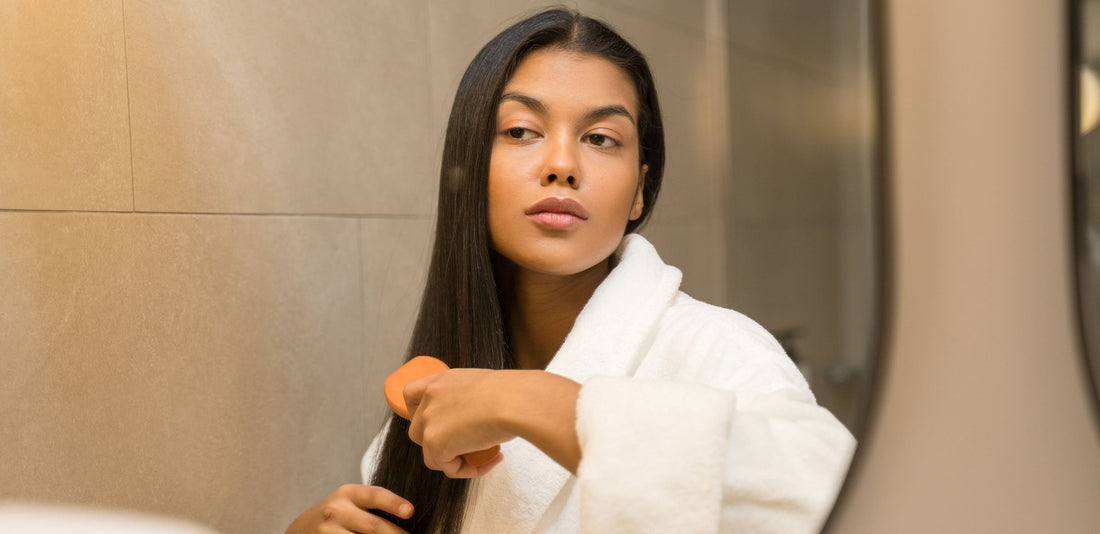 Professional model demonstrating proper hair brushing technique with salon-quality brush, showcasing glossy brunette hair with natural movement and healthy shine, illustrating professional hair maintenance results