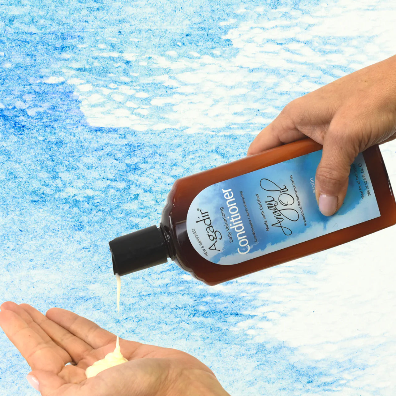 Close-up of the sulphate-free volumising conditioner being poured from the bottle, showing its creamy texture.