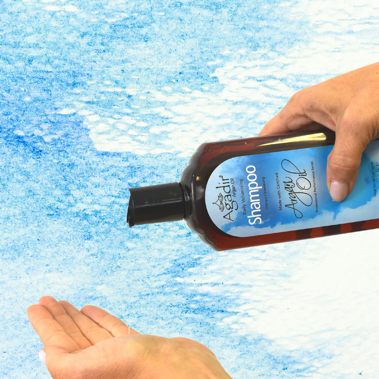 Close-up of the sulphate-free volumising shampoo being poured from the bottle, showing its rich, foamy texture.