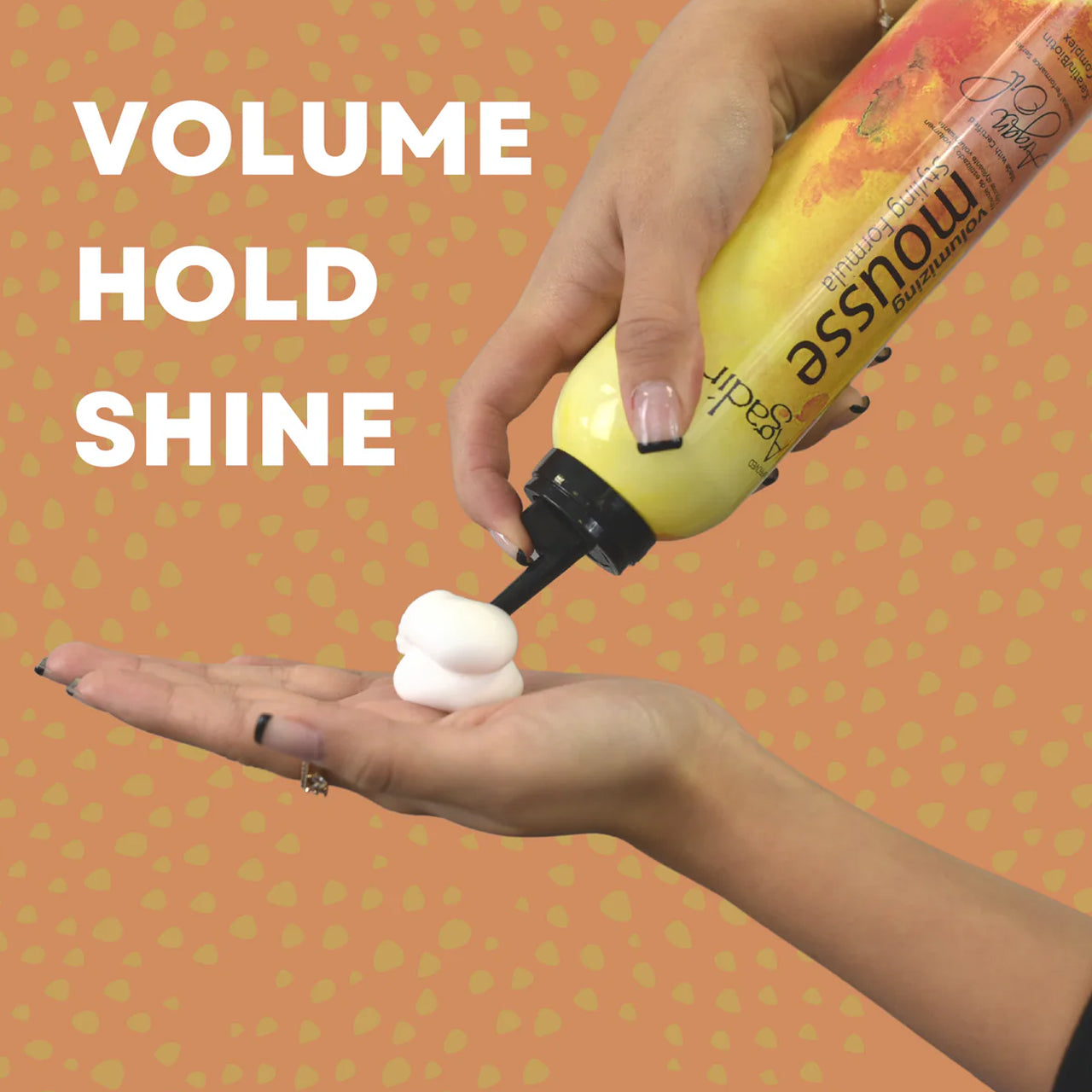 Hairstylist applying Agadir Argan Oil Volumising Styling Mousse to a model's hair for added volume.