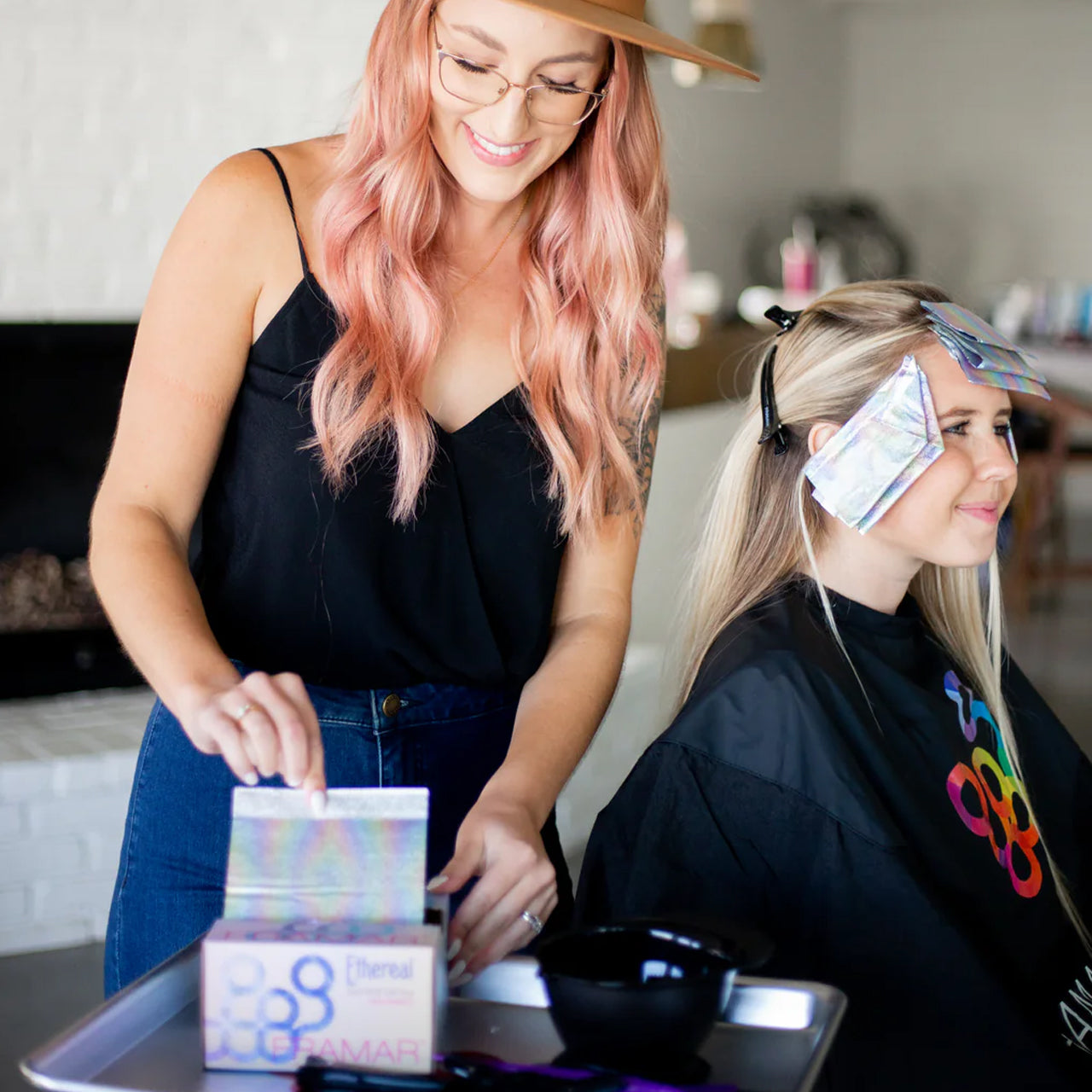 Professional hair stylist using Framar Ethereal Pop Up Foils for precise hair highlighting, demonstrating easy pop-up dispensing system with 5x11 inch sheets