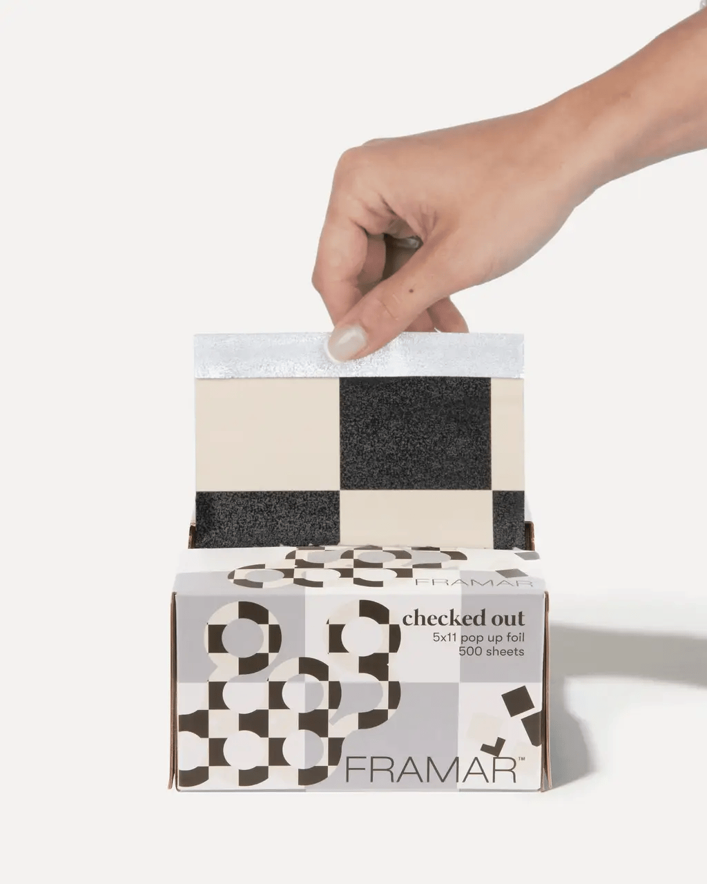 Hair stylist using Framar Checked Out Pop Up Foils for precise highlighting, showing distinctive checkered pattern